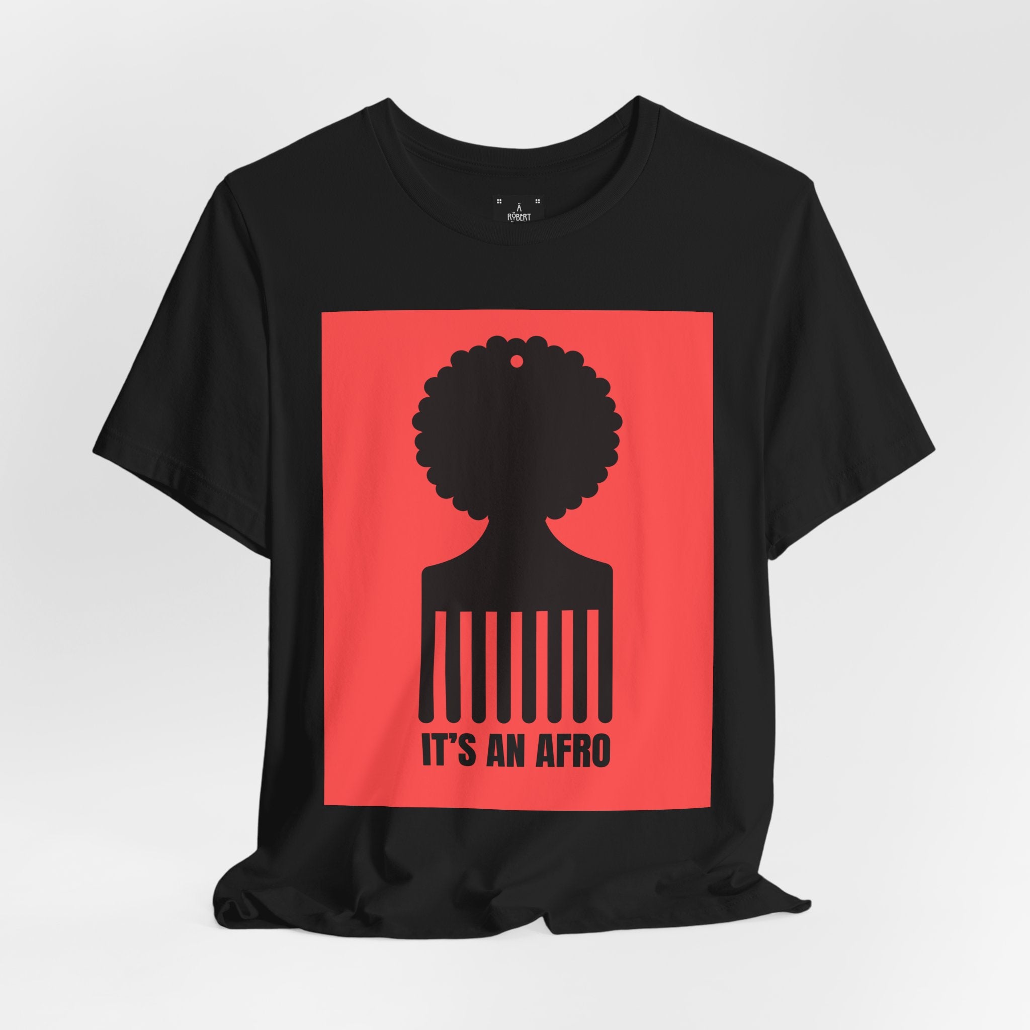 Black t-shirt with a red square graphic featuring a silhouette of a person with an afro and the text 'It's an Afro' on a white background.
